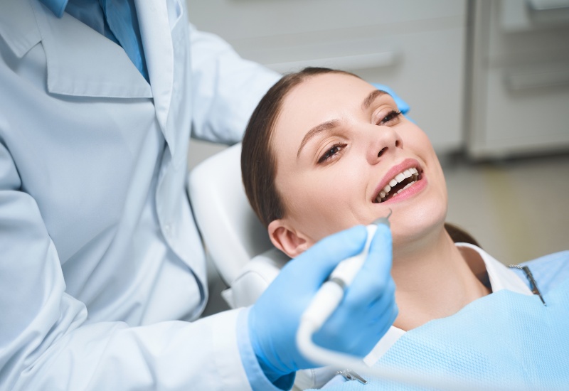 Smiling woman in a dental chair getting General Dentistry Services in Monroeville, PA
