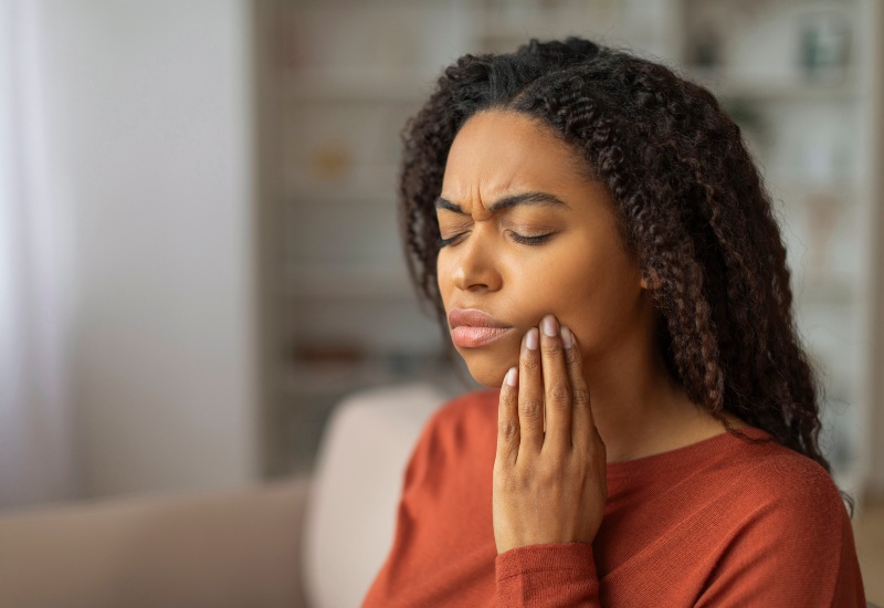 A woman experiencing severe tooth pain is illustrating a Dental Emergency in Monroeville, PA