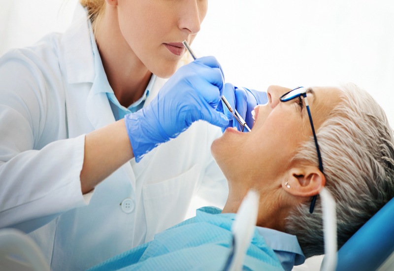A dentist performing oral cancer screening, highlighting preventive dental care in Monroeville, PA