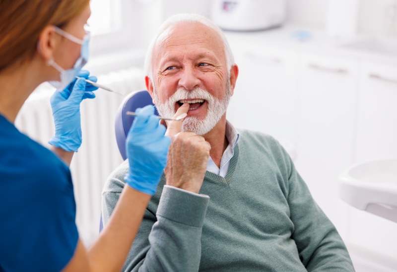 A Smiling senior man receiving a checkup, showing quality Dental Care for Seniors in Monroeville, PA