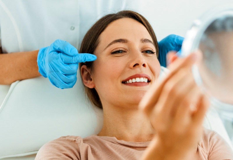 A medical professional pointing to a woman’s temple after Botox treatment in Monroeville, PA