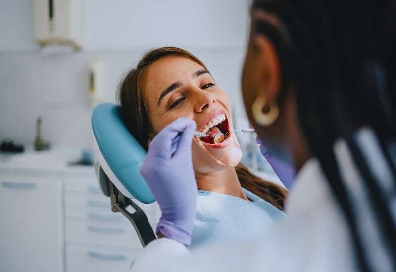 A dentist performing professional dental cleaning on a patient in a clinic in Monroeville, PA